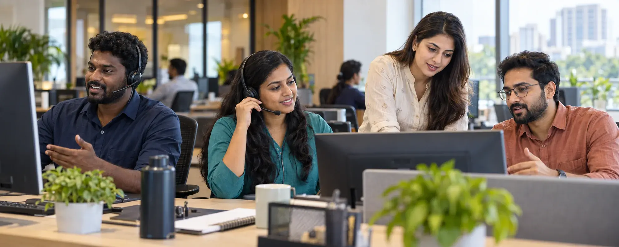 Four Indian customer support colleagues helping clients in a Chennai office